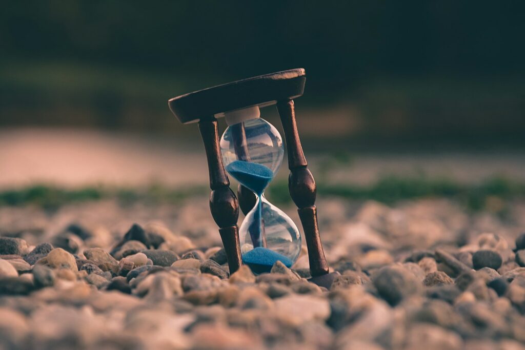 An hourglass on a desk, suggesting a deadline